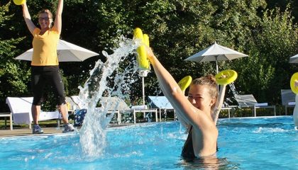 Wassergymnastik Zwei Frauen machen Wassergymnastik im Pool