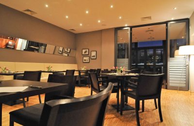 Restaurant Helles Restaurant mit schwarzen Tischen und Stühlen
