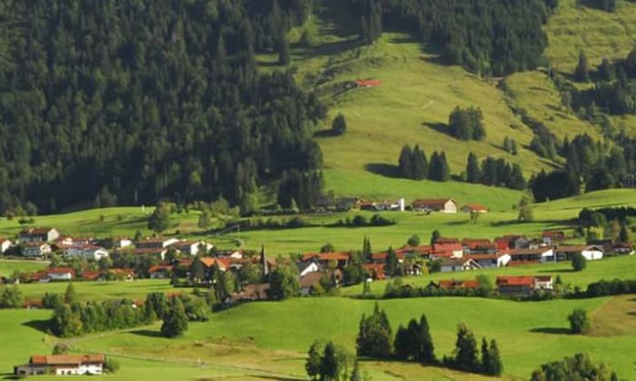 Das Allgäu erkunden Landschaftsaufnahme vom Allgäu mit grünen Wiesen, Wäldern und einem Dorf