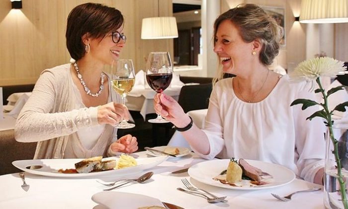 Beste Freundinnen Zwei Frauen speisen und  trinken Wein