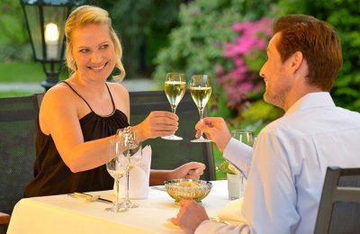 Candlelight Dinner Paar stößt bei romantischem Dinner zusammen an
