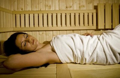 Sauna Frau in weißem Handtuch genießt Saunagang