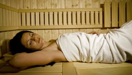 Sauna Frau in weißem Handtuch genießt Saunagang