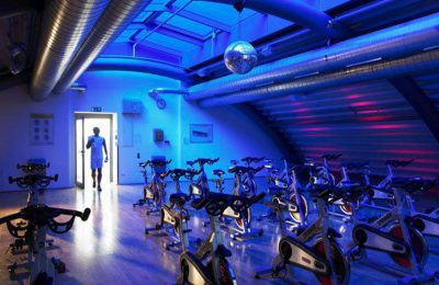 Fitnessclub Blau beleuchteter Raum mit Trainingsgeräten im Fitnessclub