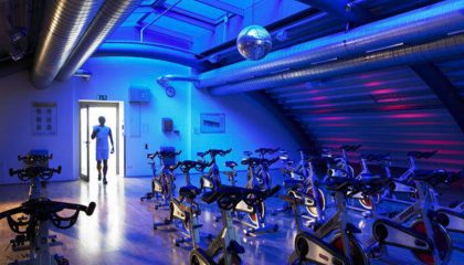 Fitnessclub Blau beleuchteter Raum mit Trainingsgeräten im Fitnessclub