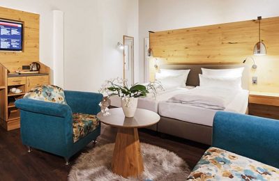 c Wohnraum und Bett im Doppelzimmer Typ 5