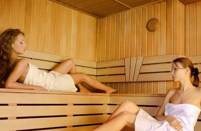 Sauna Zwei Frauen in weißen Handtüchern erholen sich in der Sauna