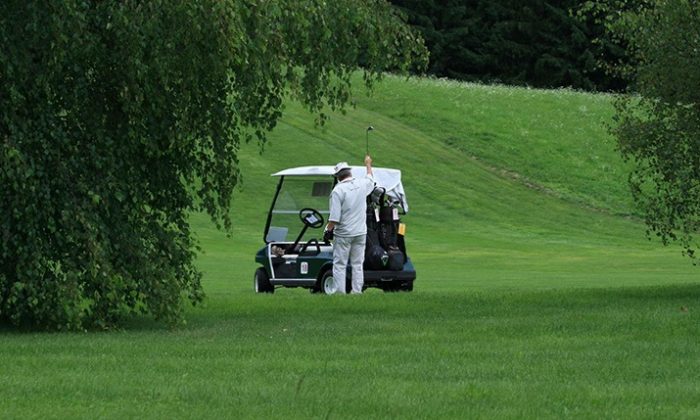Golf Golfspieler neben Golfcaddy.