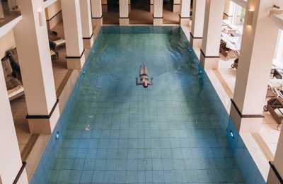 Pool von oben Frau schwimmt Bahn im Indoor Pool im Romantik Hotel Diedrich