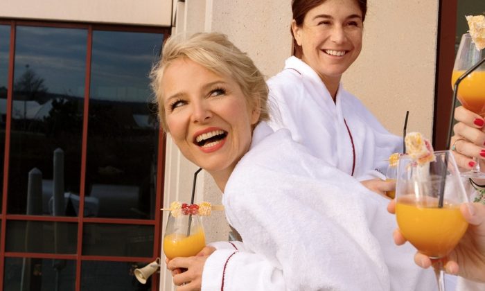 Auszeit mit Freundinnen Drei Freundinnen in weißen Bademänteln genießen erfrischende Drinks