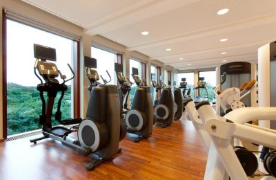 Fitnessraum Zahlreiche Trainingsgeräte vor Glaspanorama