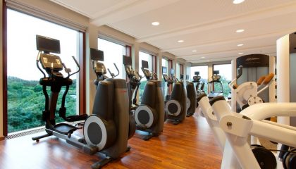 Fitnessraum Zahlreiche Trainingsgeräte vor Glaspanorama