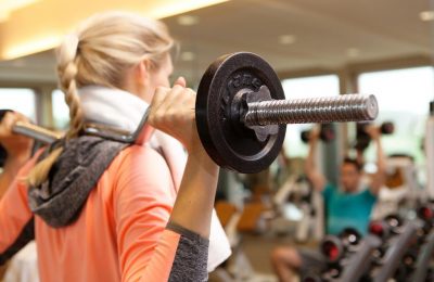 Sport Frau trainiert mit SZ-Stange im Fitnesscenter