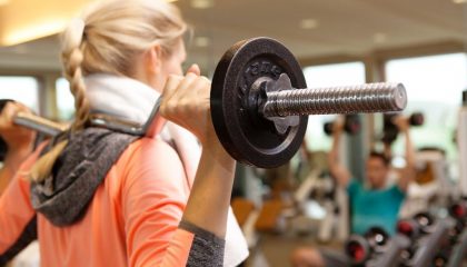 Sport Frau trainiert mit SZ-Stange im Fitnesscenter