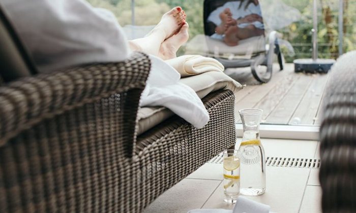 Für Dich  Mehr Infos zum Hotel  Jetzt anf Frau in weißem Bademantel erholt sich im Ruhebereich