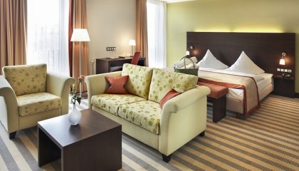 Doppelzimmer im Lichtflügel Bett und Wohnraum mit Sofas im Doppelzimmer im Lichtflügel