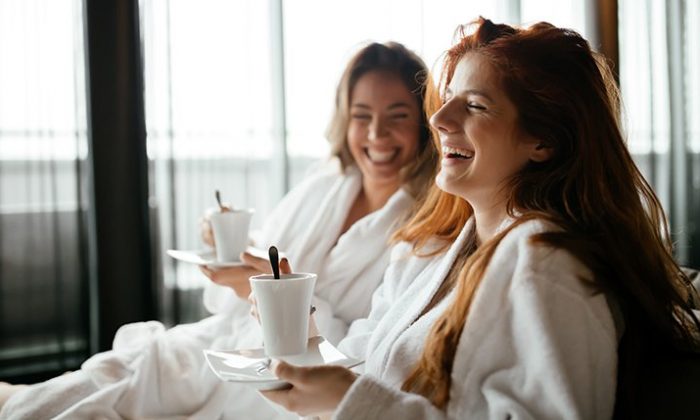 Mädelsauszeit Zwei junge Frauen in weißen Bademänteln entspannen im Spa