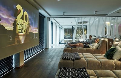 SPA Kino Paar in weißen Bademänteln schaut Film auf Leinwand im Spa Kino