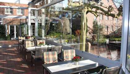 Wintergarten Tische vor Glaspanorama im Wintergarten