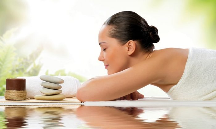 Wellness Kurzurlaub Frau in weißem Handtuch genießt Massage