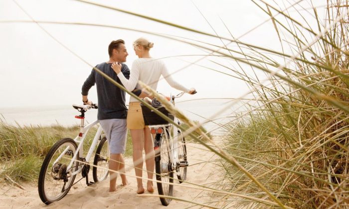 Erkunden Paar mit Fahrrädern in den Dünen von Sylt