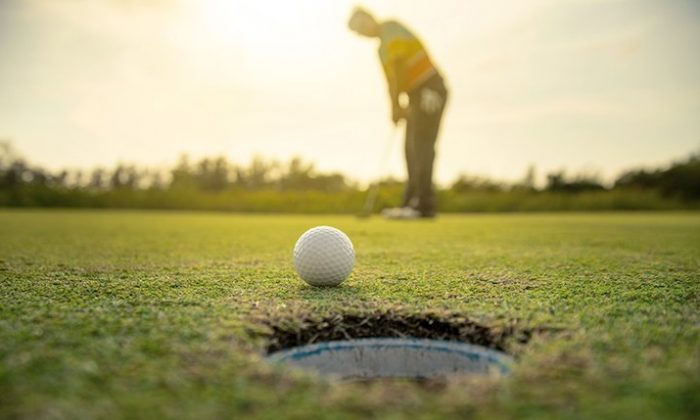 Golfen Mann spielt Golf bei Sonnenuntergang