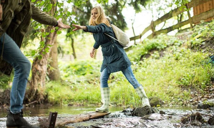 Wandern rund um Hallenberg Junges Paar überquert beim Wandern einen Bach